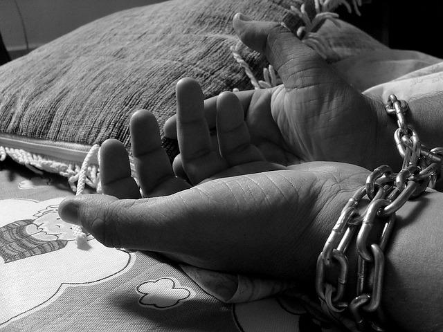 A woman hand's chained due to Human Trafficking.